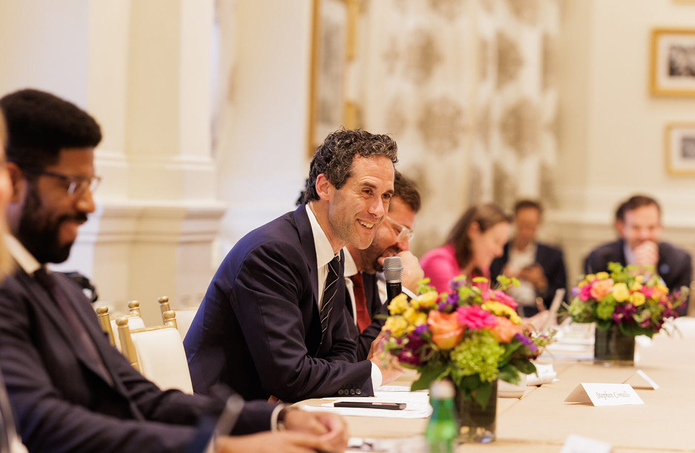 EFI team member, male, holding microphone responding to questions at event.