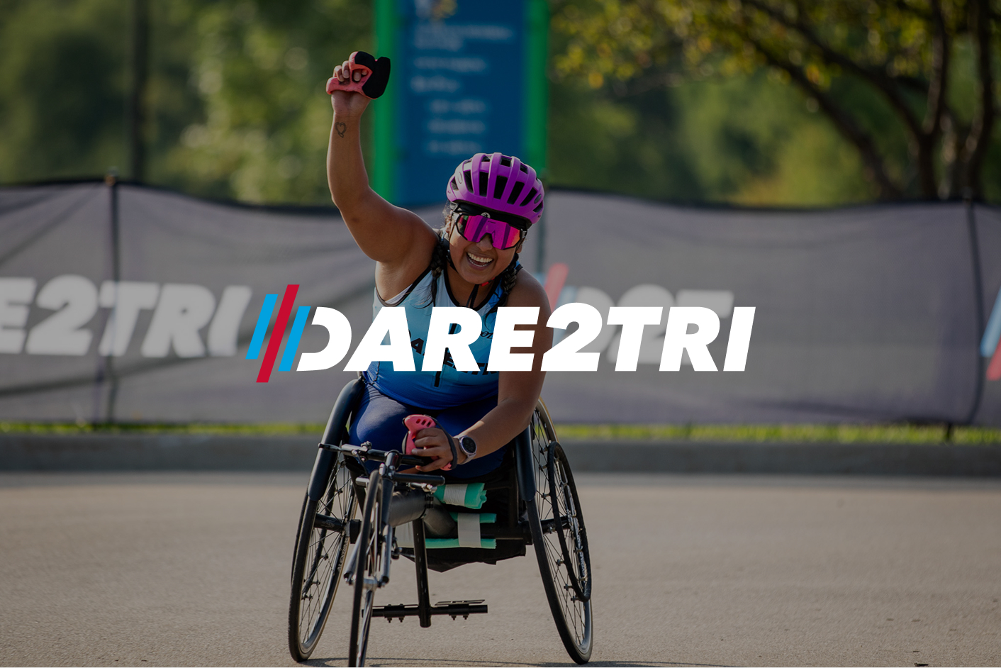 Dare2tri atlete with fist in air as she crosses the finish line of a race.