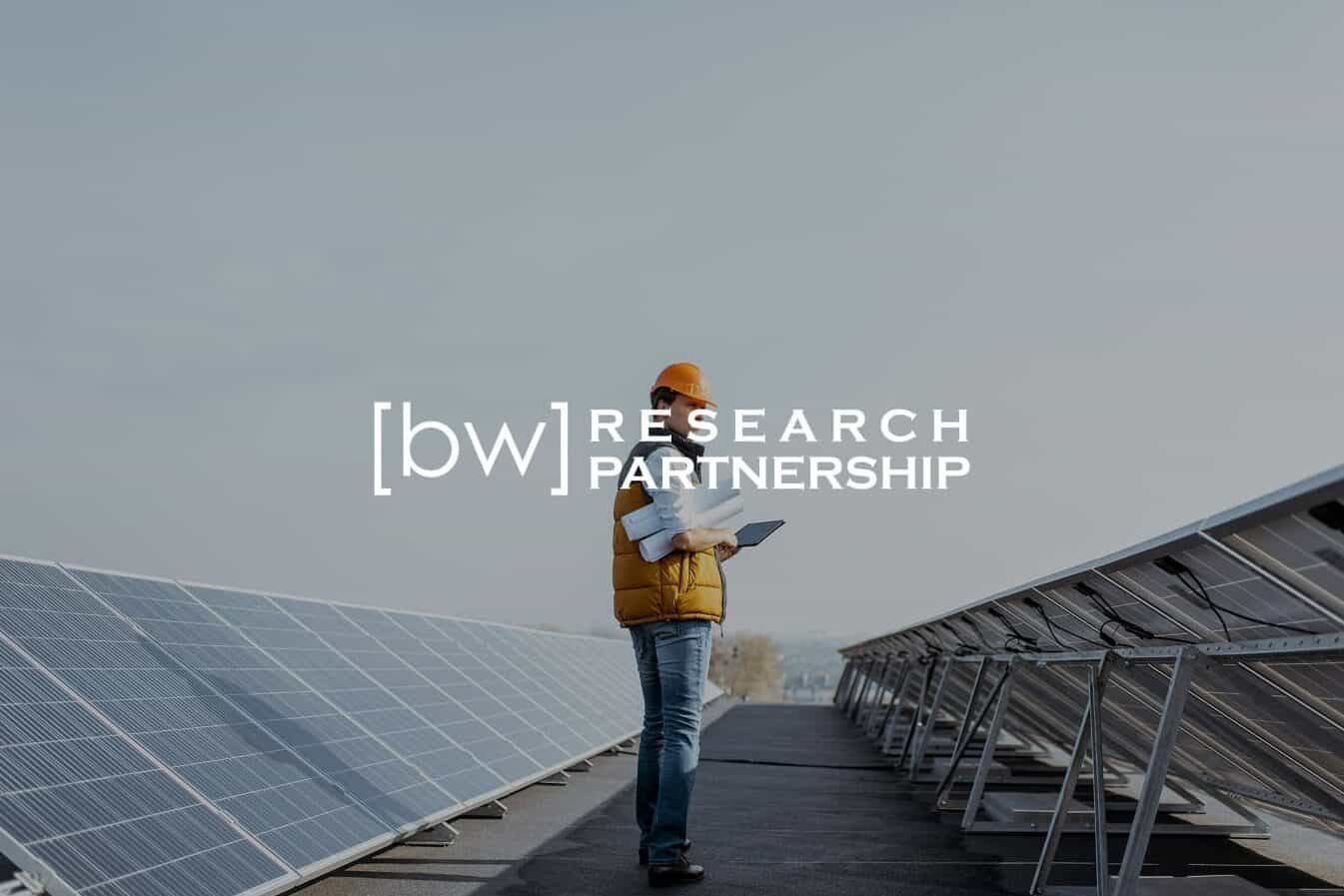 BW Research logo overlayed image of worker taking notes next to solar panels.